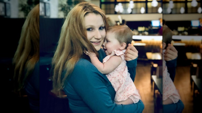 Chlesea O'Donnell holding one of her daughters in a restaurant