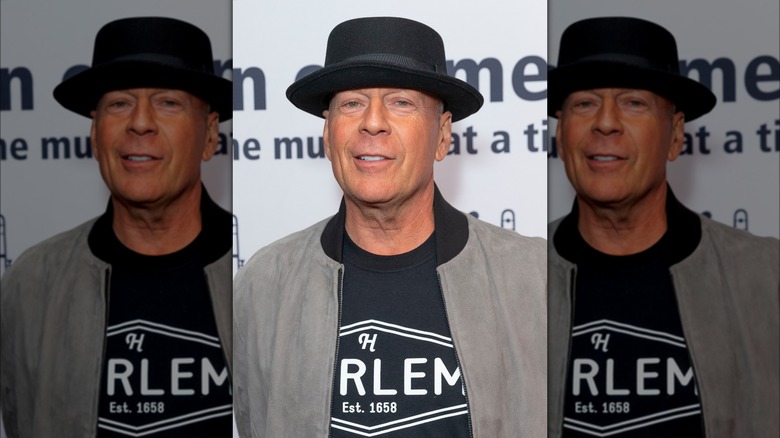 Bruce Willis wearing a hat and smiling