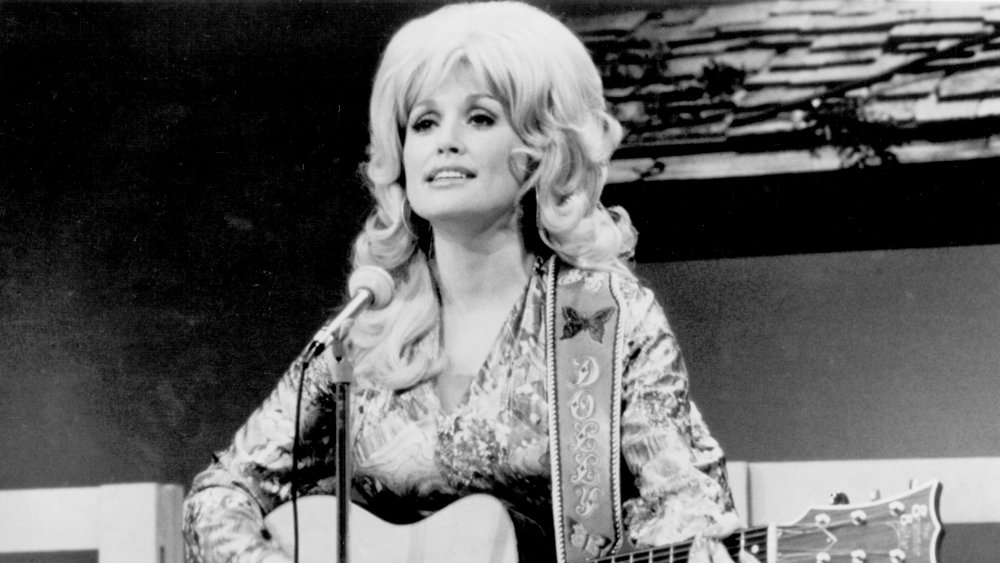 Dolly Parton playing guitar on stage in the '70s or '80s