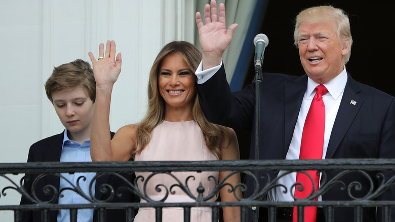 Barron Trump standing next to Melania and Donald Trump