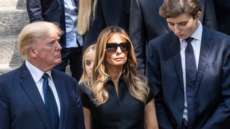 Donald and Melania Trump looking downcast with Barron Trump