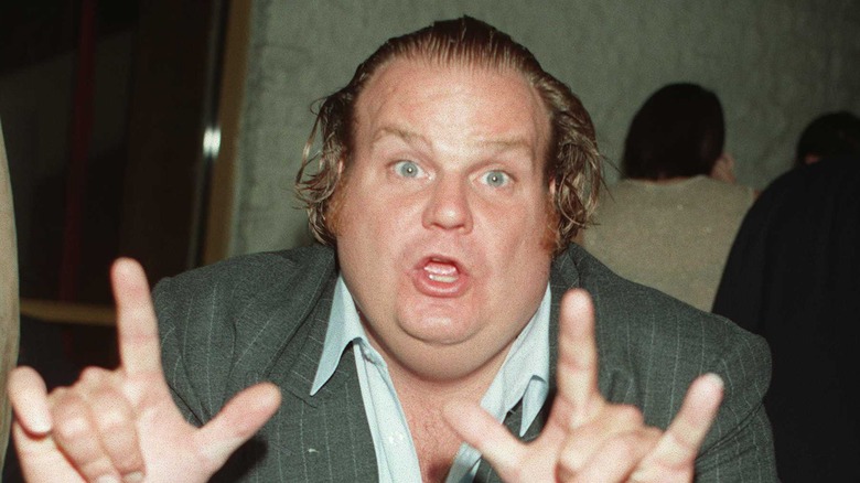 Chris Farley flashing two hand symbols 