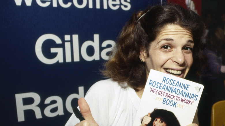 Gilda Radner posing with a book she wrote