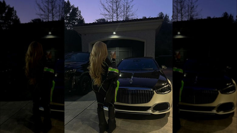 Alabama Barker in front of a car