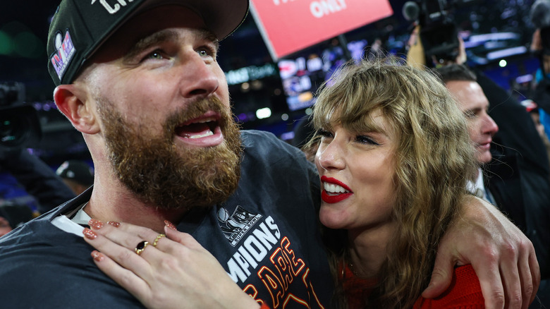 Travis Kelce has arm around smiling Taylor Swift