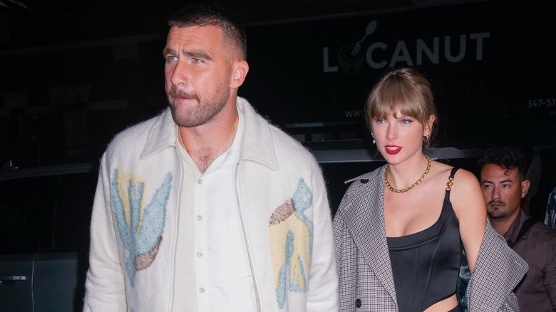 Travis Kelce and Taylor Swift walking into a restaurant