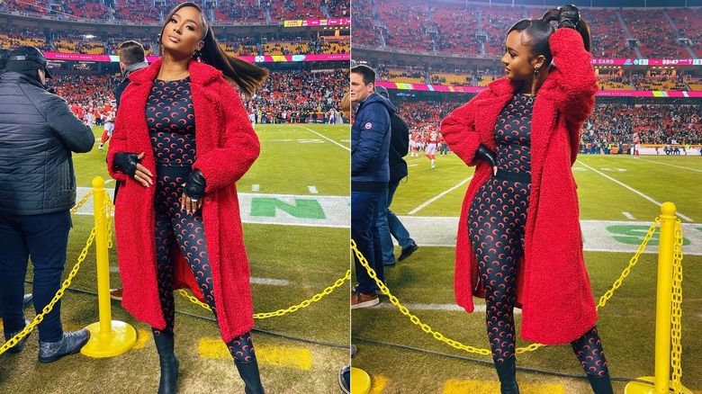 Kayla Nicole on the sidelines at a football game, wearing a skintight outfit and bright red coat.