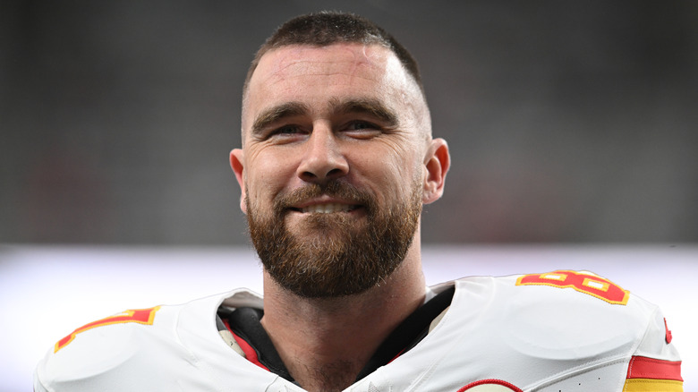 Travis Kelce smiling with a full trimmed beard