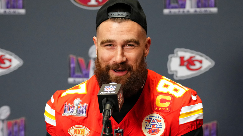 travis kelce talking into a microphone during press conference