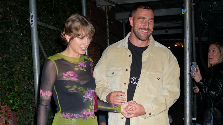 Travis Kelce and Taylor Swift smiling walking 