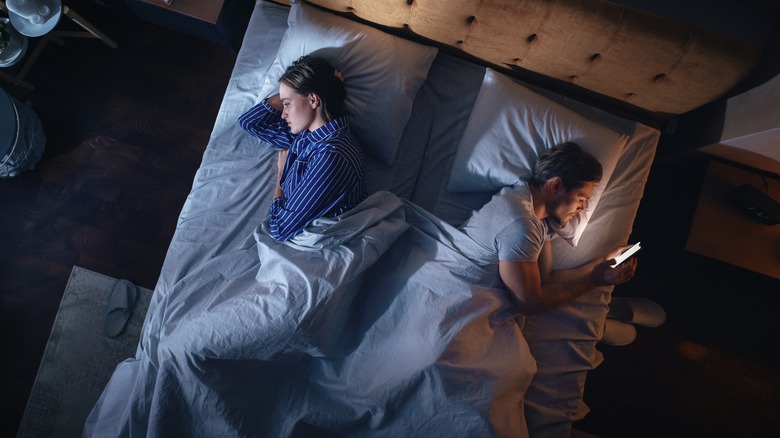 Couple facing away from each other in bed