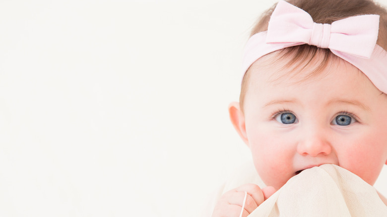 little baby girl bright blue eyes with a big bow