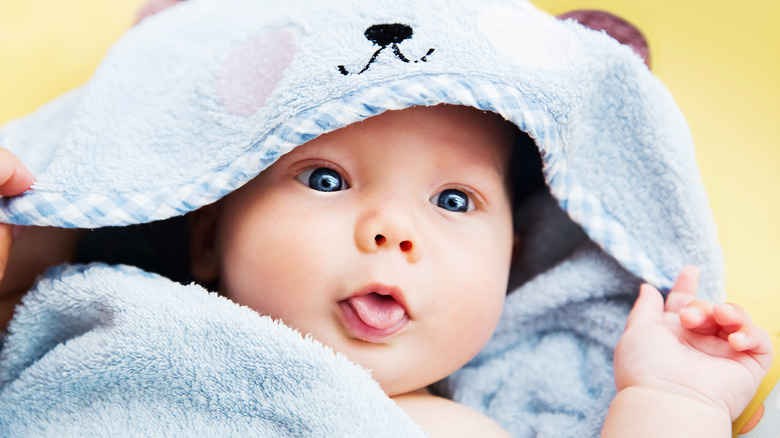 baby tongue out in a cute towel