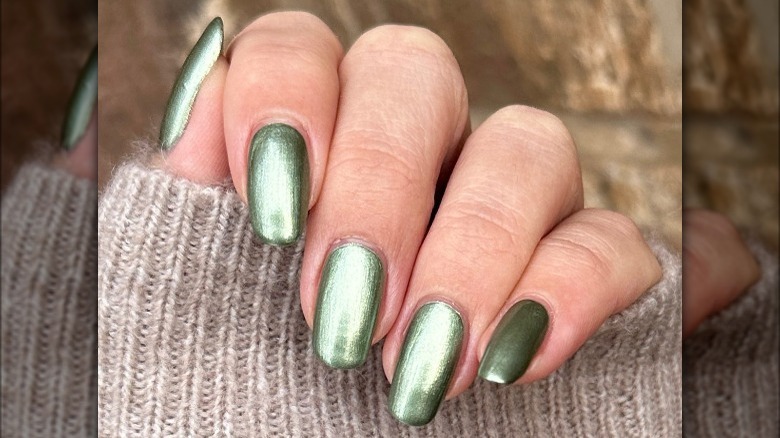 Hand with shiny green nails