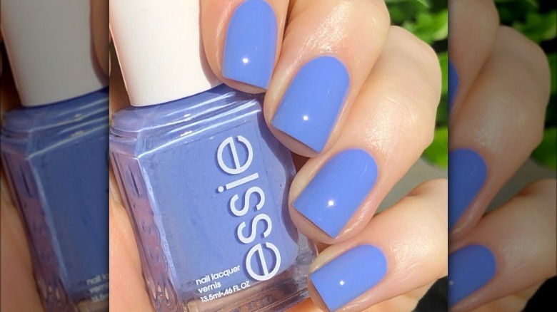 hand with periwinkle nails  holding polish