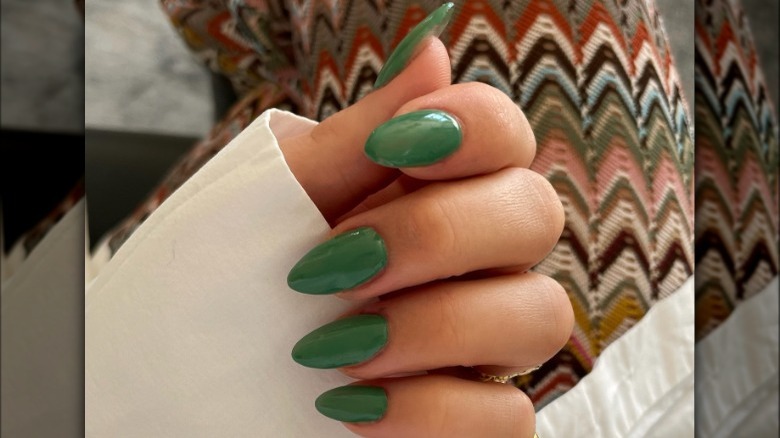 Hand with green almond-shaped nails