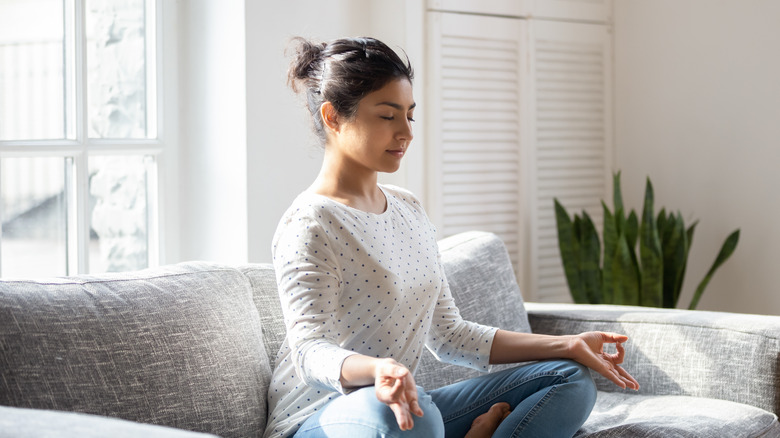 Woman on the couch practicing meditation