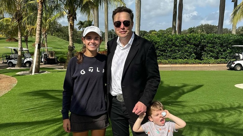 Kai Trump poses with Elon Musk and son X Æ A-12 on a golf course