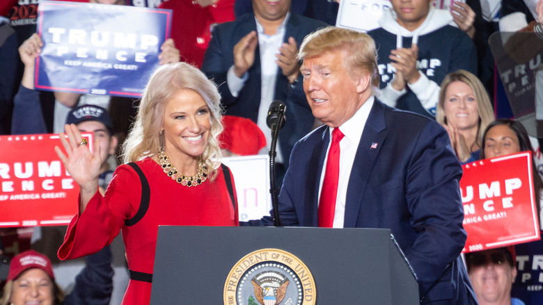 Kellyanne Conway and Donald Trump at a podium