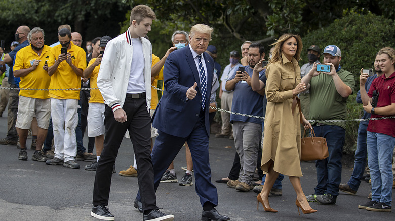 Trumps walking past crowd, Donald thumb up