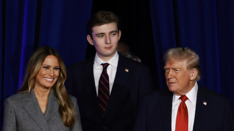 Melania, Barron, and Donald Trump posing together in formal attire