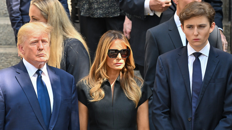 Donald, Melania and Barron Trump looking sullen at a funeral