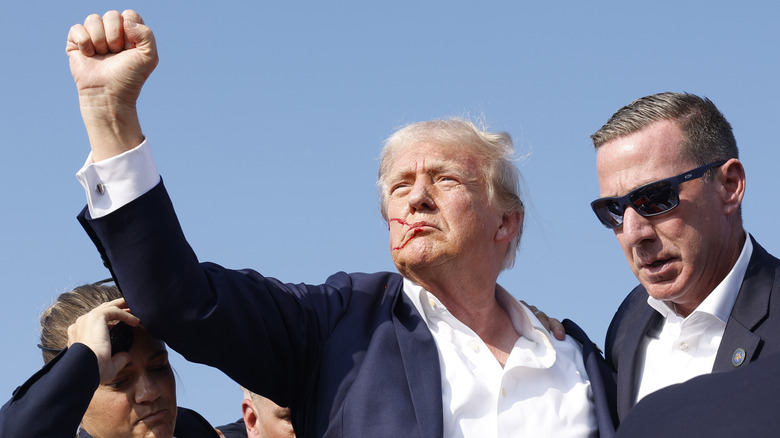 Trump raising fist with blood on his face