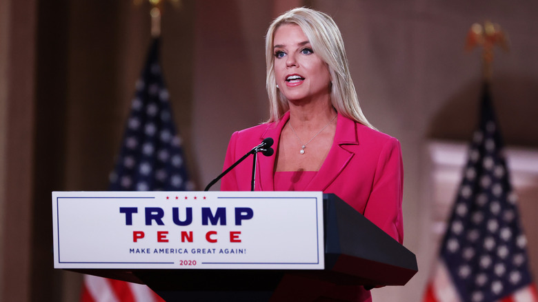 Pam Bondi speaking onstage at a Trump Vance podium