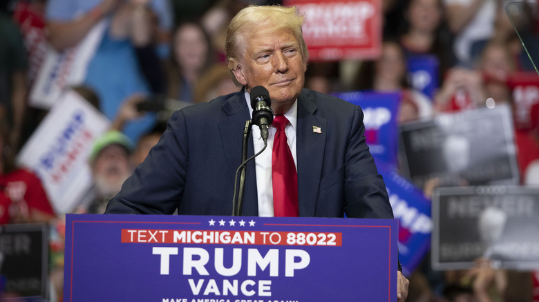 Donals Trump looking thoughtful at a podium