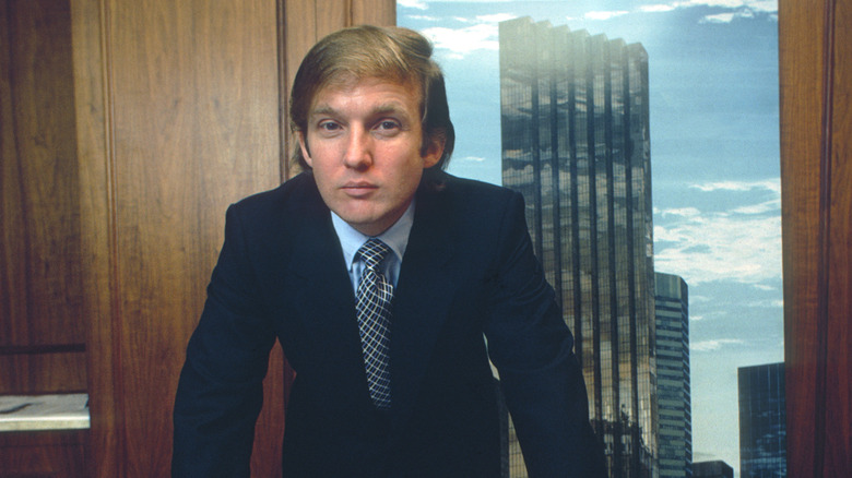 Donald Trump bending over building plans at New York Fifth Avenue in the 1980s