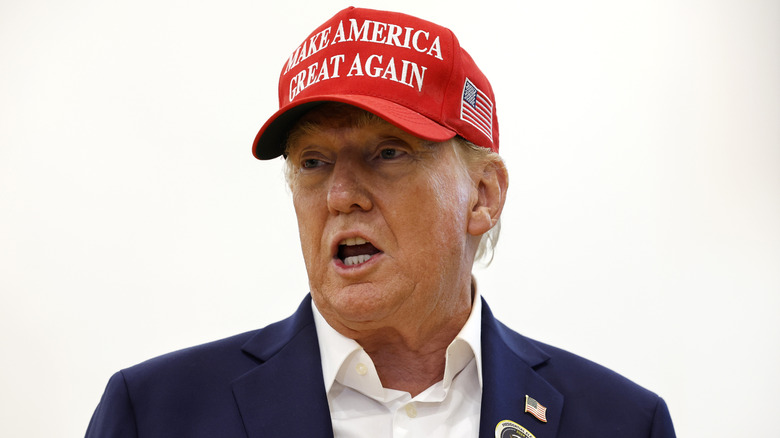 Donald Trump wearing a red MAGA hat in Palm Beach Florida