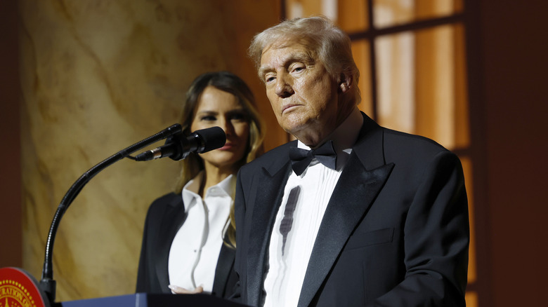 Donald Trump delivering a speech onstage in a tux looking sad