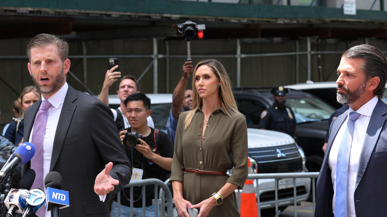 Eric Trump speaking alongside Lara Trump and Donald Trump Jr.