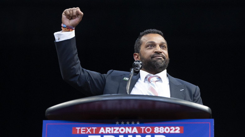 Kash Patel raising his fist during a Trump event