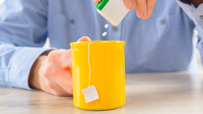 Man adding artificial sweetener