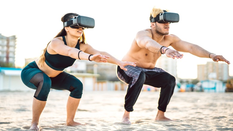 Couple squatting on the beach using VR