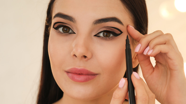 Woman applying precise makeup