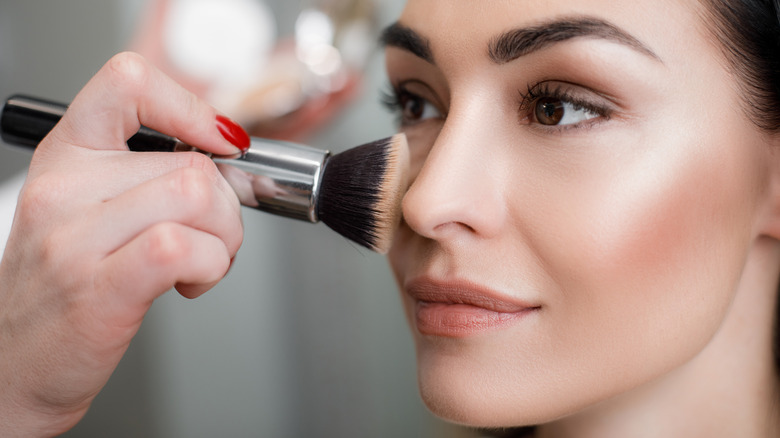 Woman applying makeup with brush