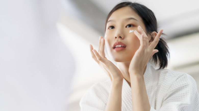 A woman moisturizing her face