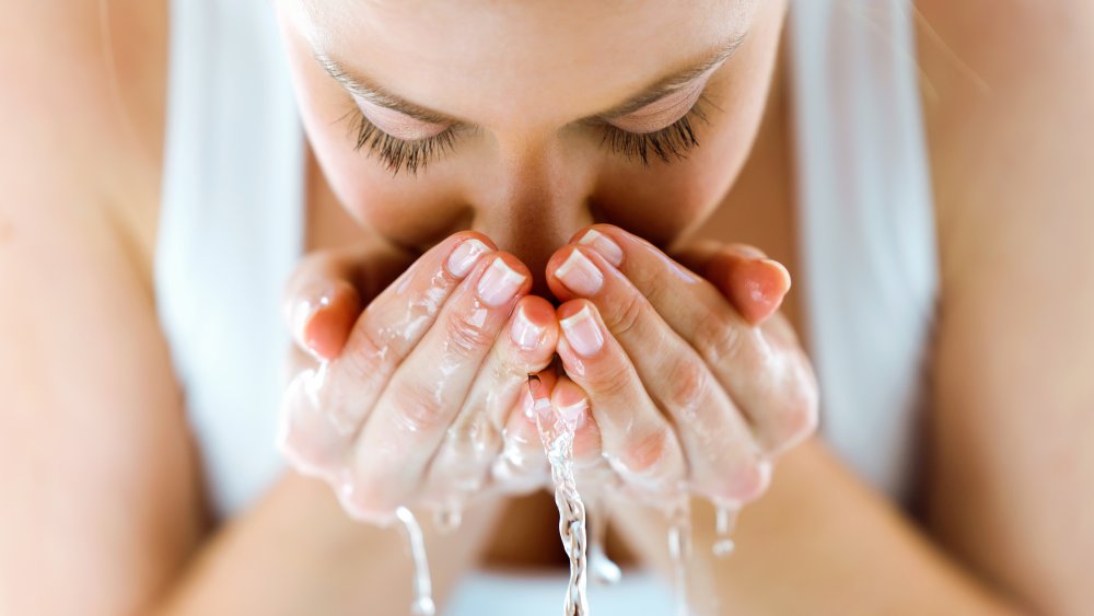 woman rinsing her face with clean water