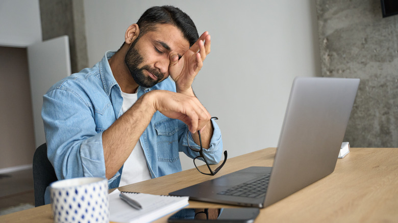 man tired at desk 