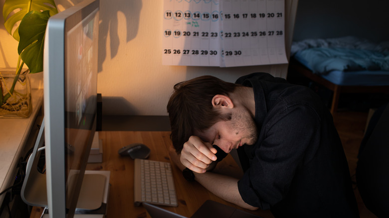 man slumped at desk 