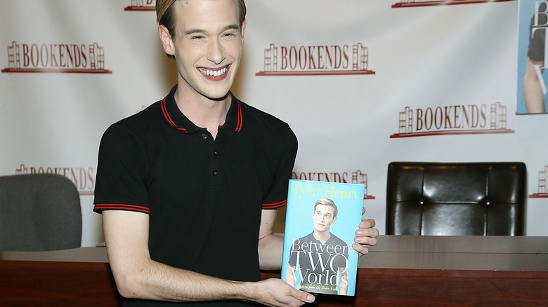 Tyler Henry holding his first book