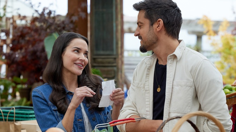 Rhiannon Fish and Tyler Hynes at an outdoor market in "A Picture of Her"