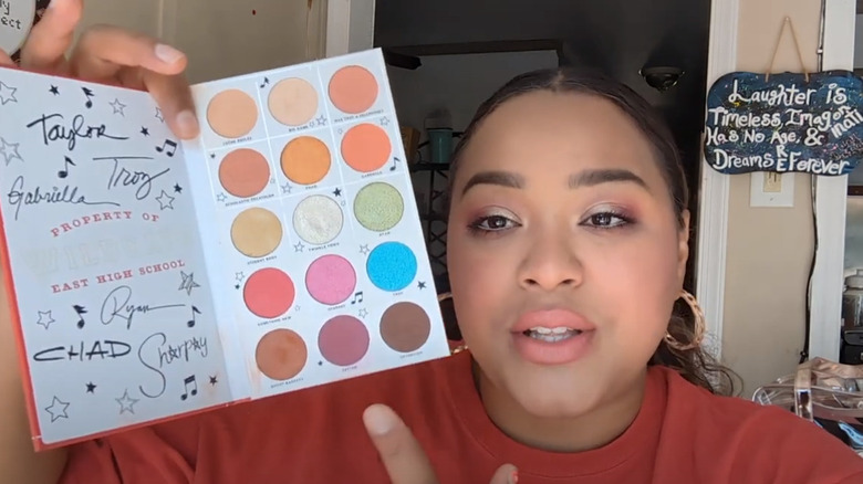 Screenshot of YouTuber Marissa Estrella holding up High School Musical palette and wearing finished makeup look