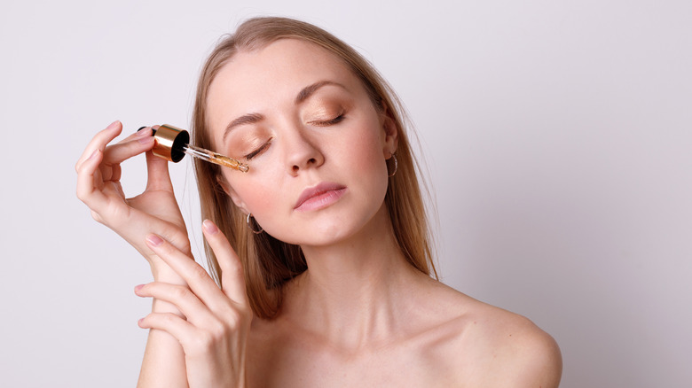 woman putting oil on her face