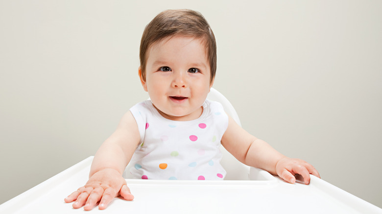  Baby smiling in high chair