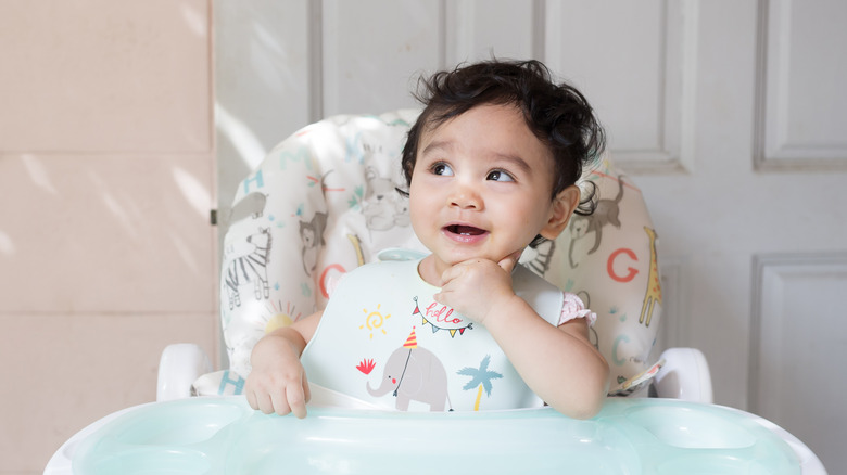 Baby smiling in high chair