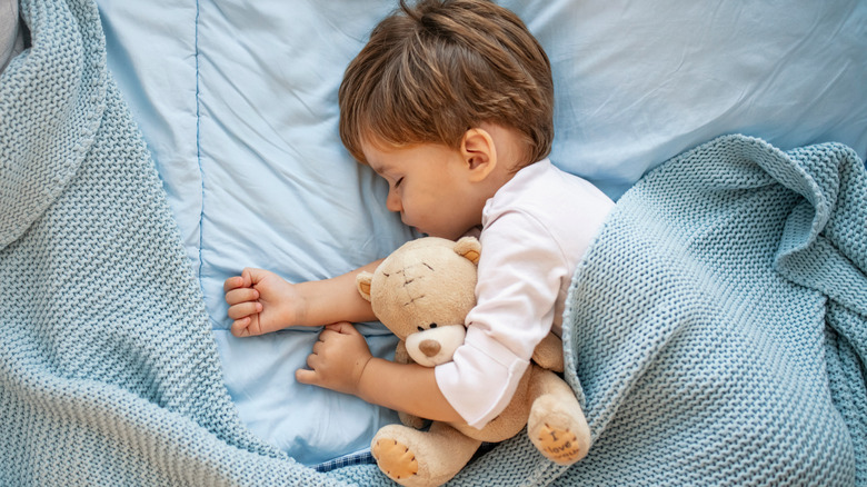 Toddler sleeping with teddy bear