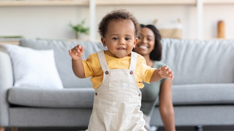 Baby smiling and wearing overalls